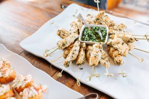 Grilled chicken skewers with colorful veggies on a plate, garnished with herbs