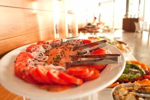 Plate of smoked salmon with lemon slices and dill on a white plate.