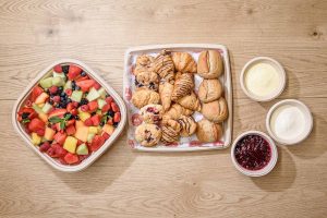 A tempting continental breakfast spread, featuring an assortment of fresh-baked croissants, scones, bread, creamy butter, fruity jam, and a selection of fresh fruits for a delightful and satisfying start to your day